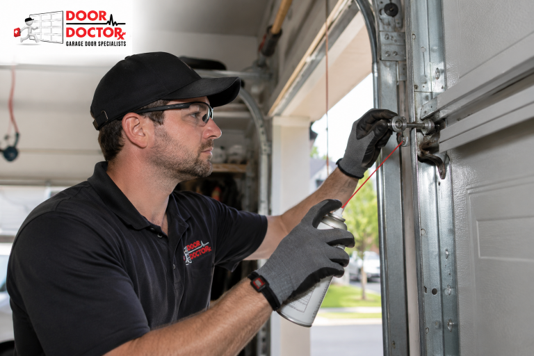 Door Doctor VA technician lubricating a garage door roller inside a residential garage in Sterling, VA.